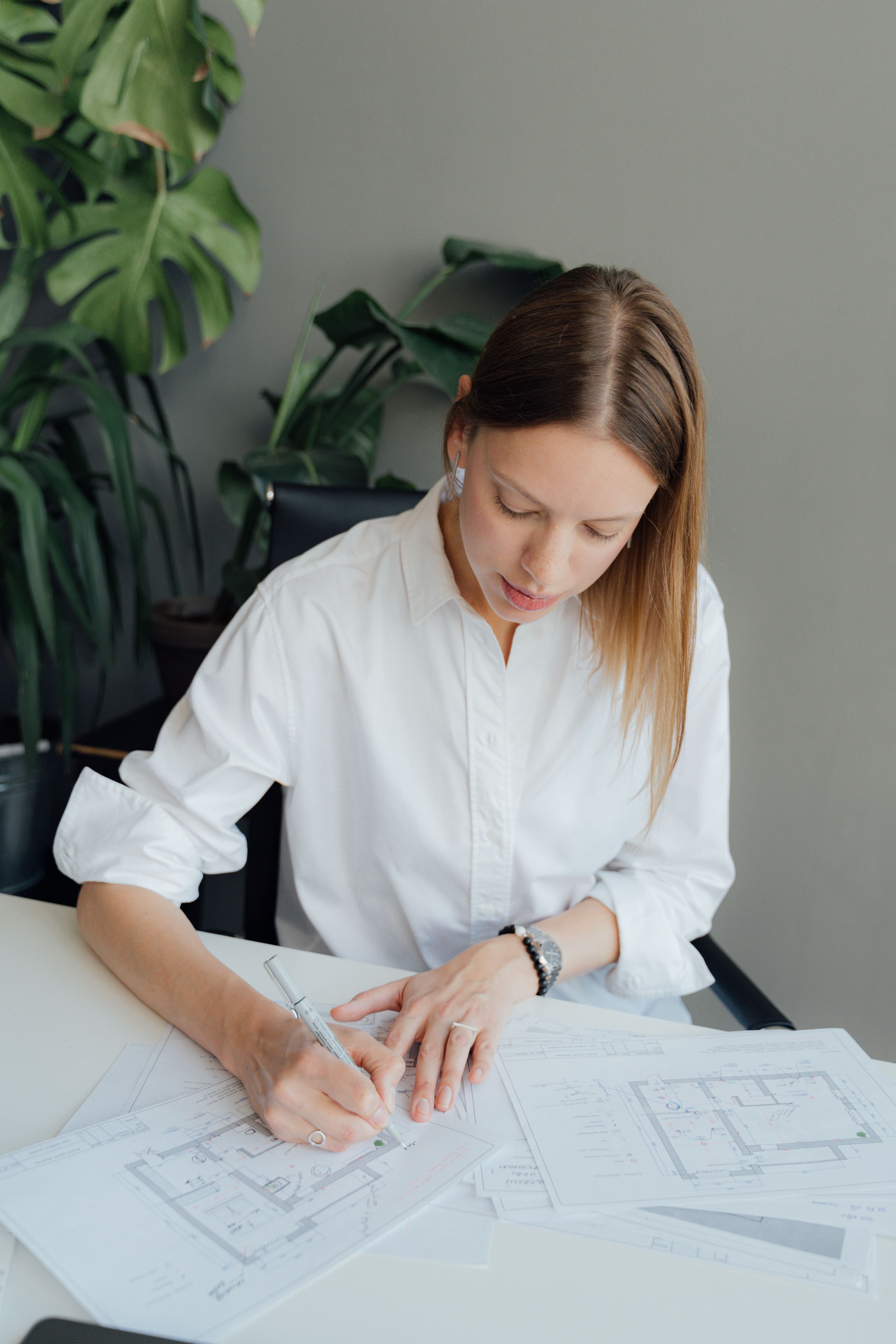 Portrait of Elena Brooks, reviewing drawings at a studio table