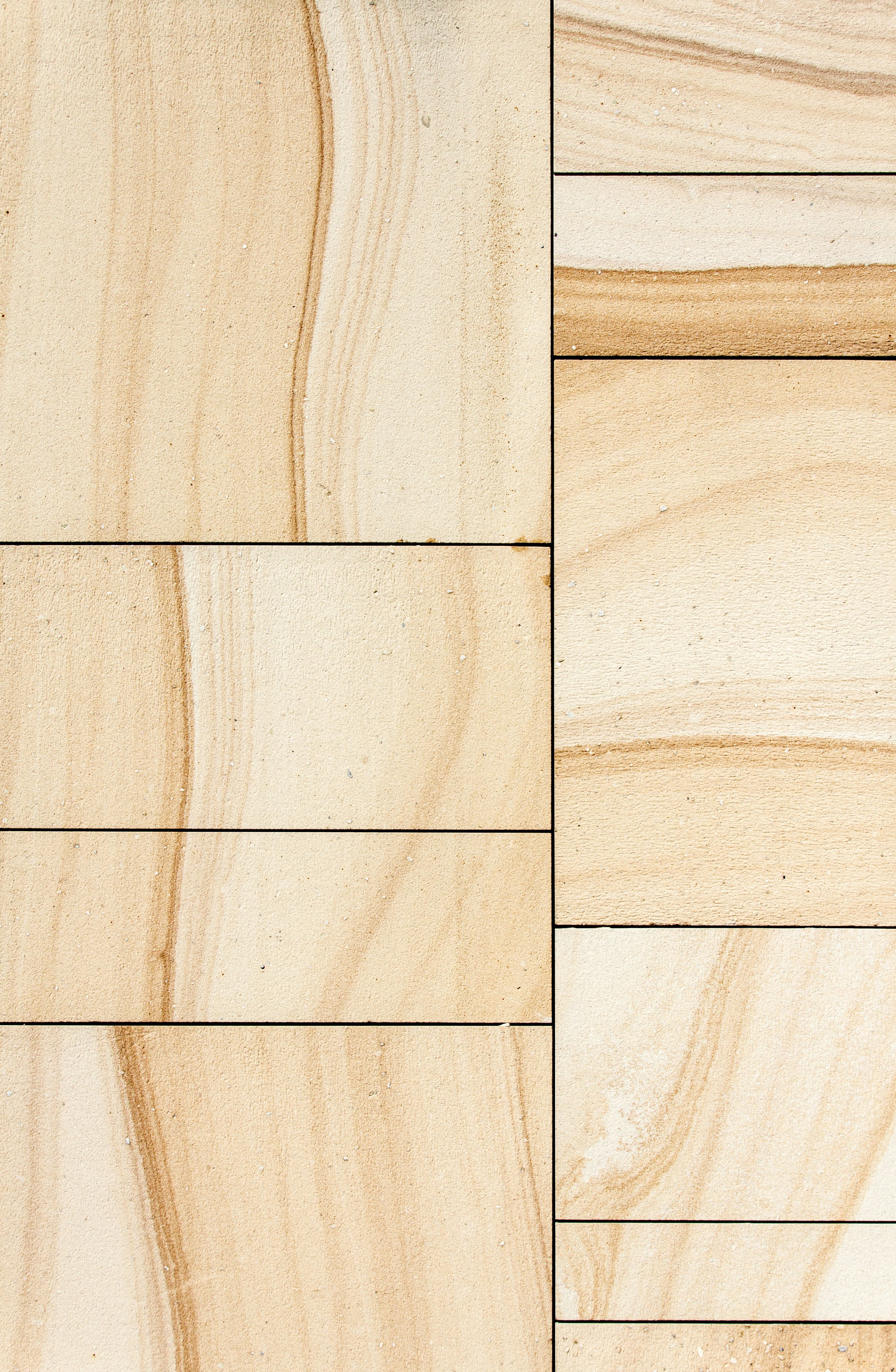 Close-up of veined limestone tiles, laid in a staggered pattern