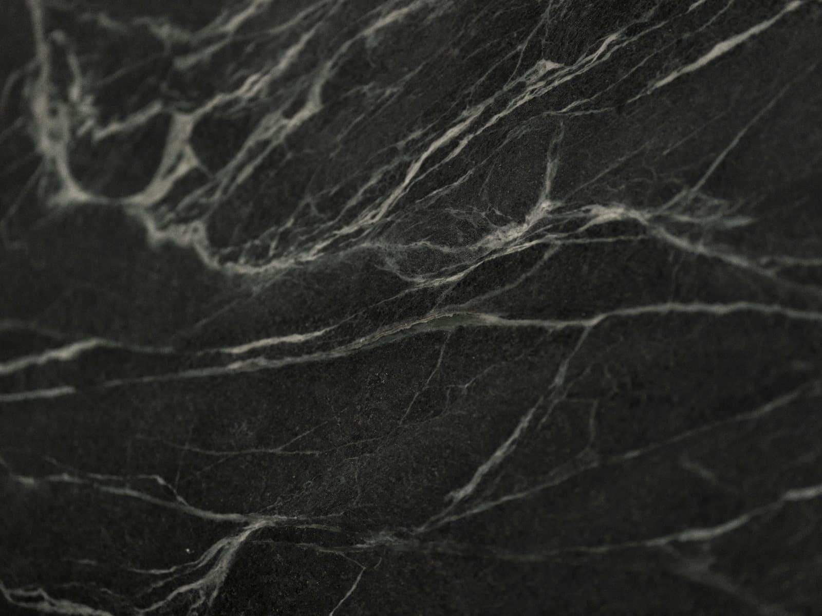 Close-up of dark honed stone with natural veining
